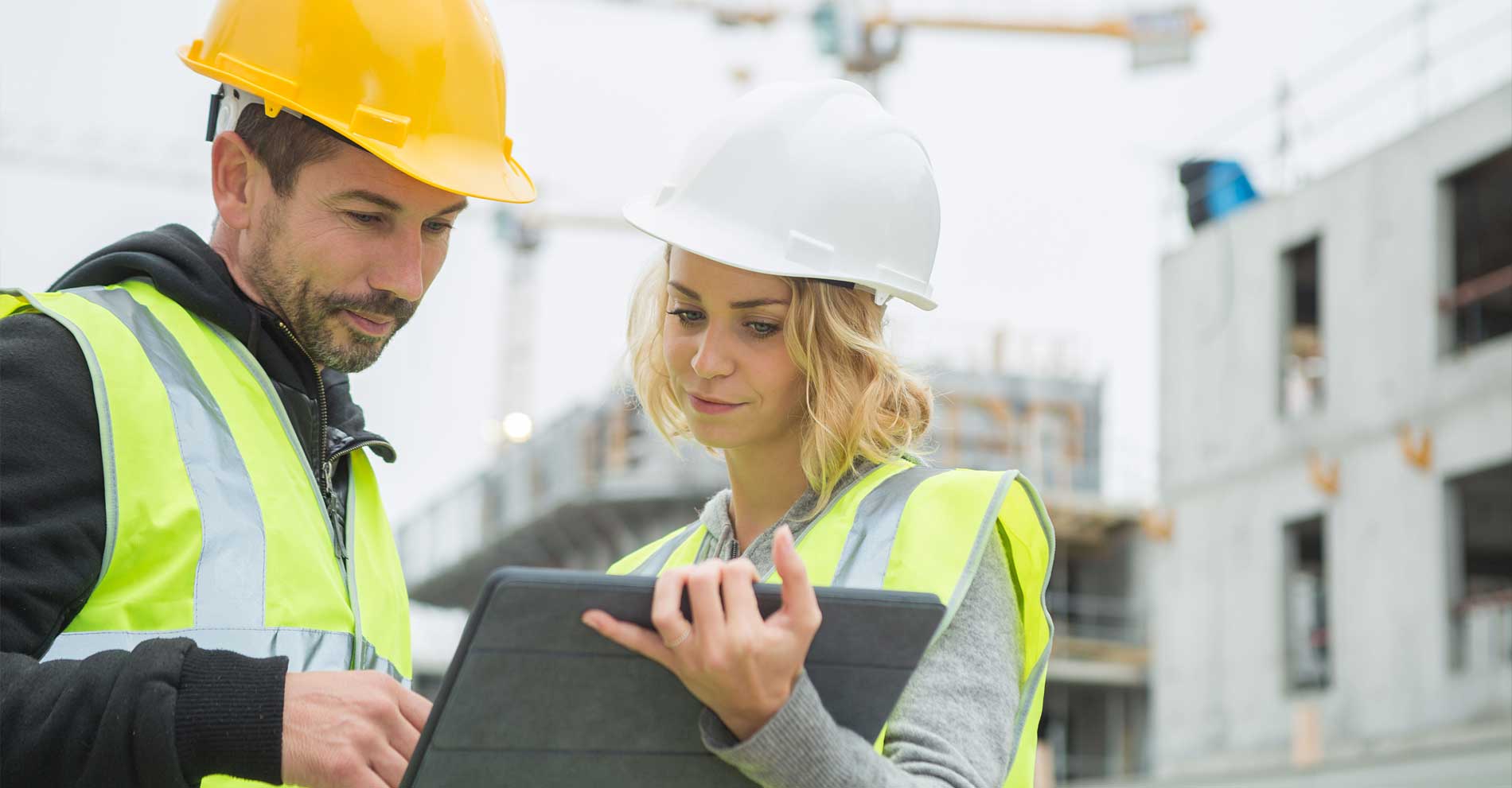 Construction man and woman looking at tablet