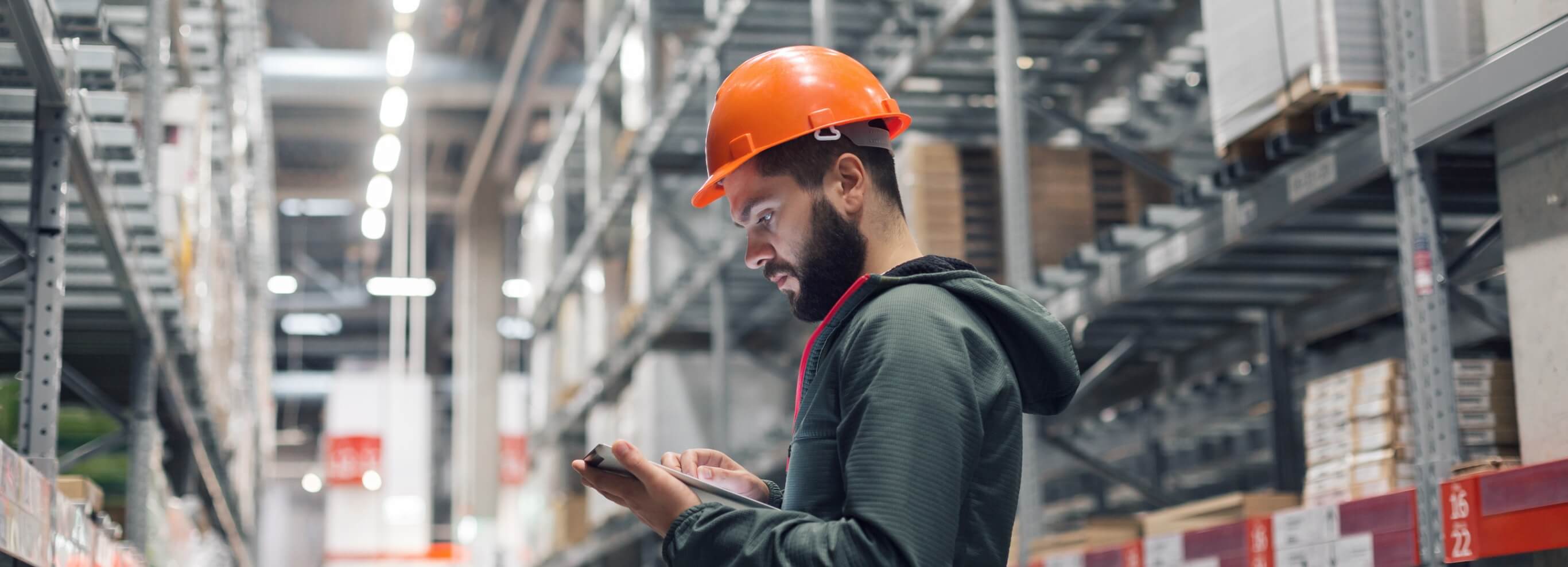 construction worker in warehouse looking at iPad